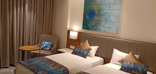 a hotel room with two beds and a table at Hotel O Rajula Formerly The Urban Hotel in Rājula