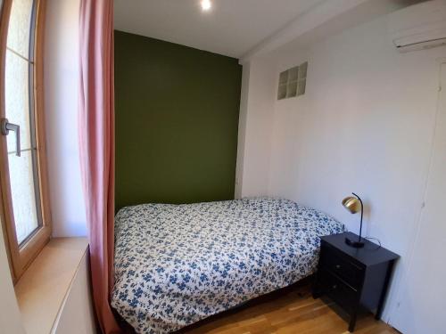 Duplex Climatisé 2chambres Centre Historique في فريجوس: غرفة نوم مع سرير وجدار أخضر