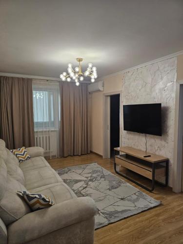a living room with a couch and a flat screen tv at Квартира in Zhezdi