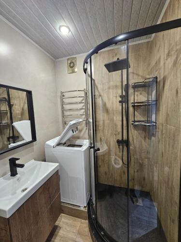a bathroom with a shower and a sink at Квартира in Zhezdi