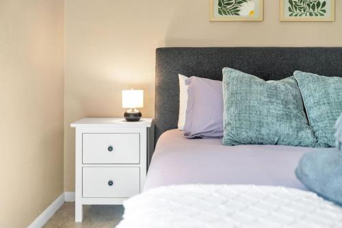 a bedroom with a bed with a night stand with a lamp at Close to beaches BBQ workout gear private yard in Largo