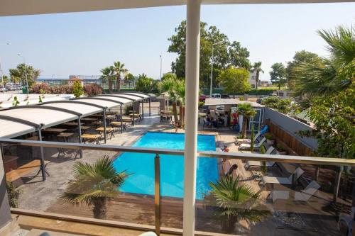 uma vista para a piscina a partir da varanda de um hotel em Cem Gül Hotel em Ayvalık