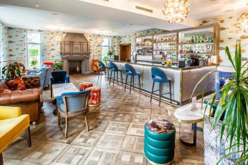 a bar in a room with chairs and a fireplace at The Wood Norton in Evesham
