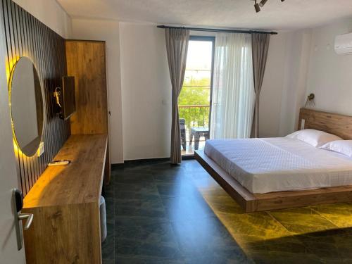 a bedroom with a bed and a mirror and a window at olives tree in Datca