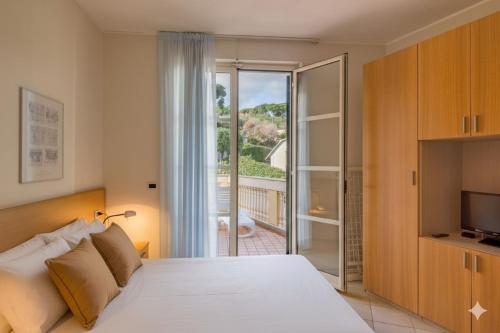 a bedroom with a bed and a sliding glass door at Residenza al Porto in Spotorno