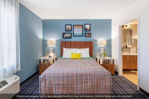a bedroom with a bed with a blue wall at Uptown Suites Extended Stay Tampa FL - Riverview in Riverview
