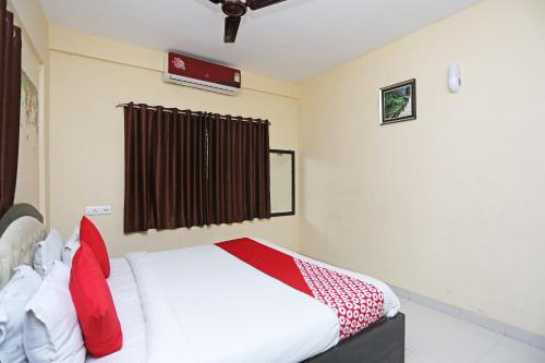 a bedroom with a bed with red pillows at Hotel O Eco Inn in Jojera