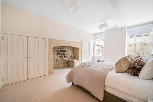 バースにあるStylish 3Bedroom Flat in Bath City Centerの白いベッドルーム(ベッド1台、暖炉付)