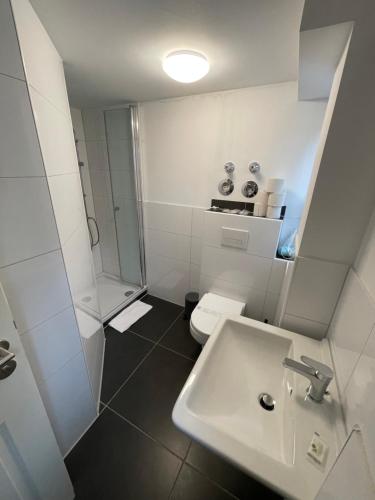 ヴッパータールにあるHaus Mees Appartementsの洗面台、シャワー、トイレ付きのバスルーム