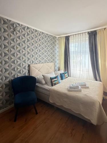 ein Schlafzimmer mit einem Bett und einem blauen Stuhl in der Unterkunft Laura in Bełchatów