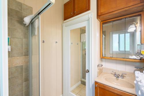 a bathroom with a shower and a sink and a mirror at Kokomo Classic 2 Bedroom Couples Cottage in Turtle Cove