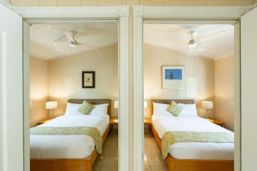 two beds in a room with two mirrors at Kokomo Classic 2 Bedroom Couples Cottage in Turtle Cove