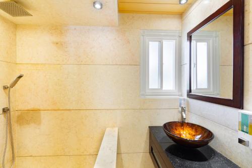 a bathroom with a bowl sink and a window at Kokomo Premium King - King Cottage in Turtle Cove