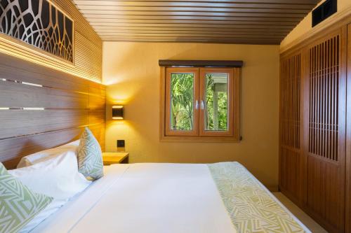 a bedroom with a bed and a window at Kokomo Ultra-lux King - King Cottage in Turtle Cove