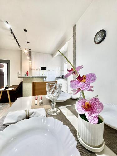 a dining room with a table with purple flowers on it at Ape Elegance com ar condicionado cama queen no centro in Formosa