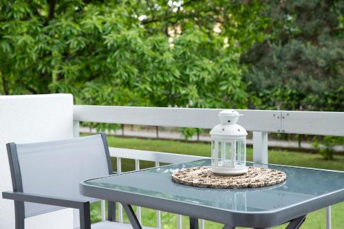 a glass lantern sitting on a table with two chairs at Elena luxury living in Paralía Skotínis