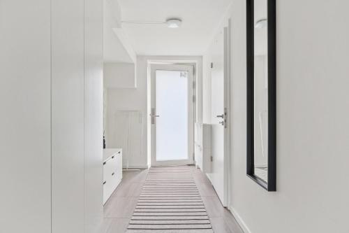 a hallway with white walls and a mirror at Modern Townhouse With Private Outdoor Area - 2BR 4 Beds in Copenhagen