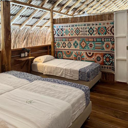 two beds in a room with a roof at Rincón del Mangle in San Onofre