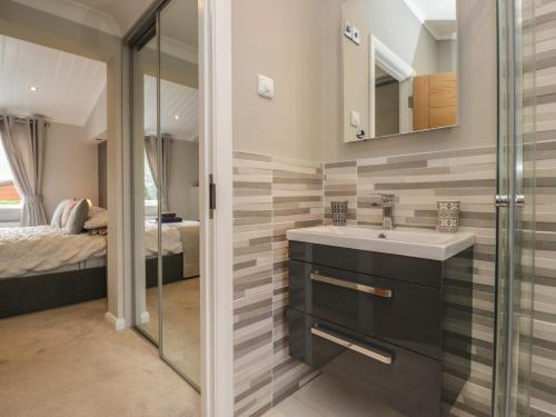 a bathroom with a sink and a shower and a bed at 7 Lake View in Troutbeck Bridge