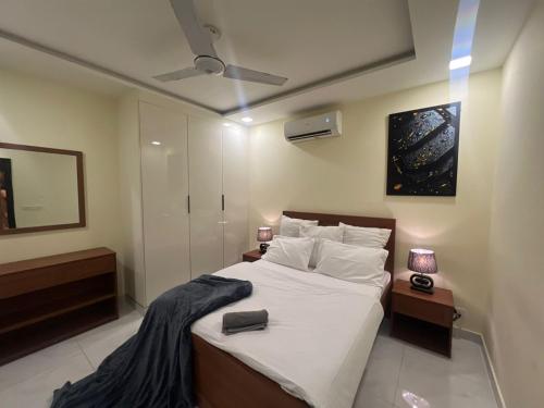 a bedroom with a large bed with white sheets at Luxor Apartments & Suites - Opal in Lahore