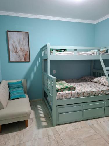 a bedroom with two bunk beds and a couch at Pousada Charmosa em Guarulhos in Guarulhos
