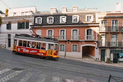 a trolley car on a city street with buildings at Lapa 82 in Lisbon