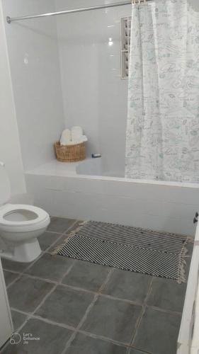 a white bathroom with a toilet and a shower at Ella villa negril in Negril