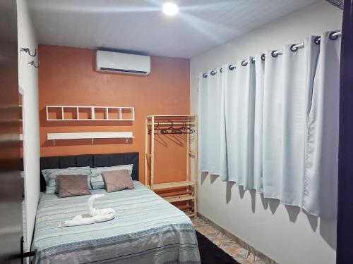 a bedroom with a bed with a white swan on it at Hospedagem Aconchego do Lar in Barreirinhas