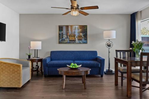 a living room with a blue couch and a table at The Suites at Fisherman's Wharf in San Francisco