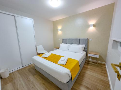 a bedroom with a large bed with a yellow blanket at Black Sand Cozy Apartment in Livramento