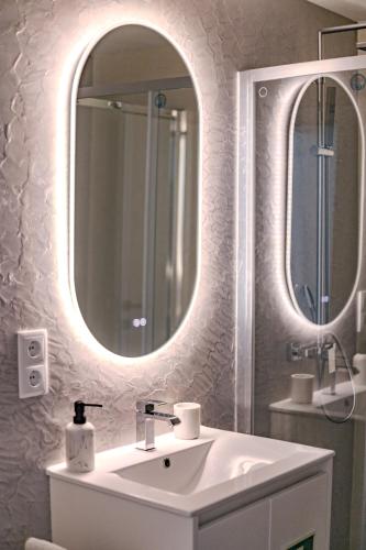 a bathroom with a sink and a mirror at Black Sand Cozy Apartment in Livramento