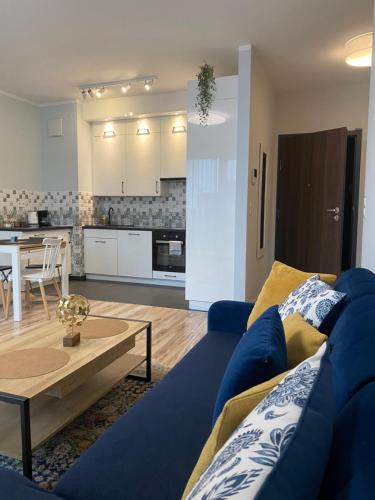 een woonkamer met een blauwe bank en een tafel bij Good Time Apartments 104 Komfortowy apartament w sercu Starego Miasta in Poznań