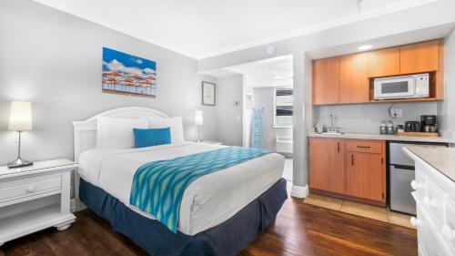 a bedroom with a large bed and a kitchen at Pelican Pointe Clearwater Beach Hotel in Clearwater Beach