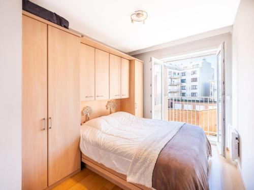 a bedroom with a bed and a large window at Guernsey tweede in Sint-Idesbald