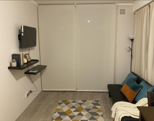 a living room with a couch and a tv at Centro I Costanera I Con Estacionamiento I 2Habs in Puerto Montt