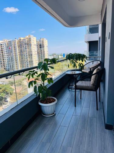 a balcony with two chairs and a table and a plant at Raydil Homes in Nairobi