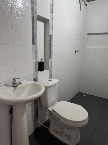 une salle de bain blanche avec toilettes et lavabo dans l'établissement Casa Campestre DONDE MAMI ENA, à Galapa