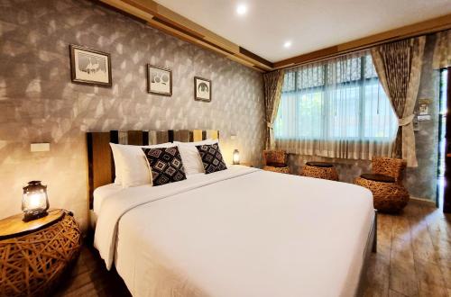 ein Schlafzimmer mit einem großen weißen Bett und einem Fenster in der Unterkunft Focal Local Bed & Breakfast in Bangkok