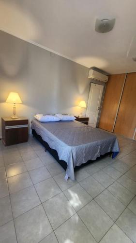 a bedroom with a bed with two night stands and two lamps at Puntacho in Funes