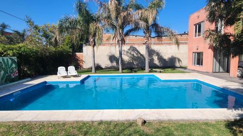 a swimming pool with two chairs and a building at Puntacho in Funes