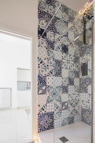 a bathroom with a shower with blue and white tiles at Relais Luxury Retreat - Seafront Apartments in Salerno