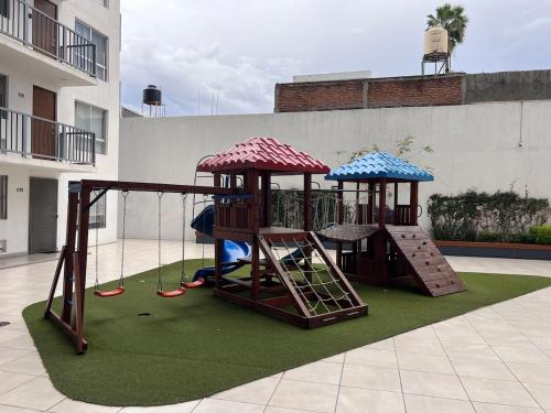 a playground with two play equipment on a lawn at Centrally located apartment with AC, parking and pool in Guadalajara