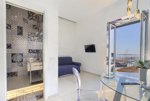 Una sala de estar con una mesa de cristal y un sofá azul. en Relais Luxury Retreat - Seafront Apartments, en Salerno