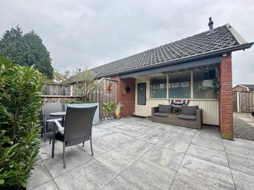 a patio with chairs and a table and a house at Het Vosje in Hengelo