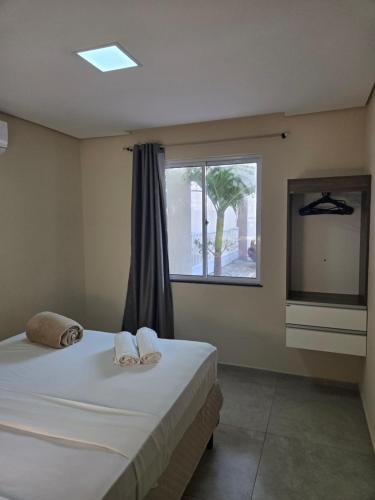 a bedroom with two beds and a large window at Residencial Amora in Fortaleza