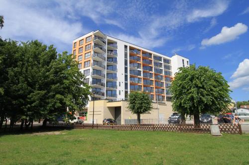 un gran edificio blanco con árboles delante de él en Horyzont by Baltic Home en Międzyzdroje