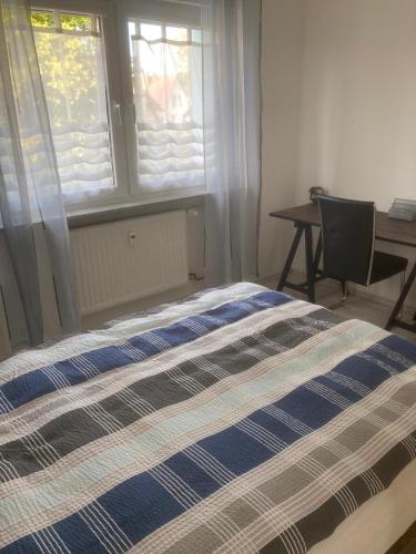 a bed in a room with a window and a desk at Ferienwohnung für Monteure in Erlenbach am Main