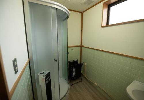 a bathroom with a shower and a sink at 鈴籠城 全室貸切 in Nagahama