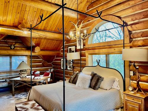 a bedroom with a bed in a log cabin at Sundance cabincasita sleeps 18 hottub firepits in Sundance