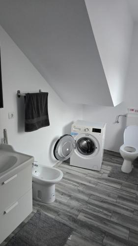 a bathroom with a washing machine and a toilet at Casa Magurele 3 in Măgurele